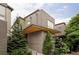 Modern home featuring a brick exterior, cantilevered porch roof, green roof and mature evergreens at 7080 W Custer Ave, Lakewood, CO 80226