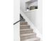 Carpeted staircase with white trim and a modern black railing, leading to the upper level of the home at 7080 W Custer Ave, Lakewood, CO 80226