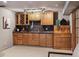 Finished basement bar featuring wooden cabinets, granite countertop, wine rack, and bar tap at 2317 Wynterbrook Dr, Highlands Ranch, CO 80126