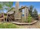 Back of house featuring a tall chimney, deck, and stairs leading to the backyard at 2317 Wynterbrook Dr, Highlands Ranch, CO 80126