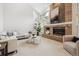 Light-filled living room with a brick fireplace, large windows, and comfortable seating at 2317 Wynterbrook Dr, Highlands Ranch, CO 80126