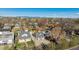 An aerial view of a property showcasing its location within a residential area surrounded by mature trees and city views at 3929 Federal Blvd, Denver, CO 80211