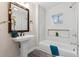 Bathroom featuring a pedestal sink, a large framed mirror, and a shower over tub combination at 3929 Federal Blvd, Denver, CO 80211
