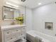 Bright bathroom featuring a vanity, a soaking tub with white marble surround, and recessed niche storage at 3929 Federal Blvd, Denver, CO 80211