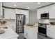 Bright kitchen featuring white cabinetry, stainless steel appliances, and a movable island at 3929 Federal Blvd, Denver, CO 80211