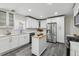 Bright kitchen featuring white cabinetry, stainless steel appliances, and a movable island at 3929 Federal Blvd, Denver, CO 80211
