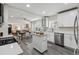 Bright kitchen featuring white cabinetry, stainless steel appliances, and an open-concept view of the dining and living areas at 3929 Federal Blvd, Denver, CO 80211