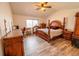 Spacious bedroom features a wooden four-poster bed, ceiling fan, and large windows for natural light at 5283 E 131St Dr, Thornton, CO 80241