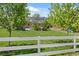 Expansive backyard with mature trees, a well-manicured lawn, and a classic American home in the background at 895 Nile Ct, Golden, CO 80401