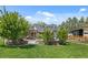 Beautifully landscaped backyard featuring lush lawn, mature trees, patio seating, and charming home at 895 Nile Ct, Golden, CO 80401