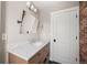 Bright bathroom featuring modern vanity, marble countertop and accent brick wall at 895 Nile Ct, Golden, CO 80401