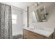 Elegant bathroom with marble countertop, wood cabinets, and shower with stylish curtain at 895 Nile Ct, Golden, CO 80401