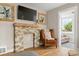 Cozy living room featuring a stone fireplace, hardwood floors, and view to a sun room at 895 Nile Ct, Golden, CO 80401