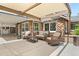 Covered outdoor patio featuring stone accents, comfortable seating, and a peaceful backyard setting at 895 Nile Ct, Golden, CO 80401