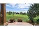 Beautiful golf course view from the back patio with red roses and a manicured lawn at 14232 Piney River Rd, Broomfield, CO 80023