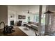 Bright living room features a fireplace, ceiling fan, and large windows offering natural light at 14232 Piney River Rd, Broomfield, CO 80023
