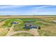 Wide aerial shot of a property featuring a home, barn, and a large, fenced-in yard at 32800 E 137Th Way, Brighton, CO 80603