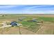 Expansive aerial view showcasing the property with a blue two-story home, outbuildings, and open land at 32800 E 137Th Way, Brighton, CO 80603