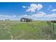 Metal outbuilding on a large grassy lot with an American flag flying, offering ample space at 32800 E 137Th Way, Brighton, CO 80603
