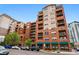 Apartment building exterior featuring brick facade, balconies, and ground-floor shops at 1975 N Grant St # 810, Denver, CO 80203
