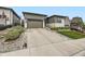Modern home showcasing a spacious driveway, manicured lawn, and rock landscaping at 2105 Bellcove Dr, Castle Pines, CO 80108