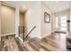 Inviting hallway with modern railing and view of the entry door and large sidelight windows at 2105 Bellcove Dr, Castle Pines, CO 80108