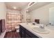 Bathroom featuring double sinks, dark wood cabinets, and a shower-tub combo with stylish shower curtain at 286 Western Sky Cir, Longmont, CO 80501