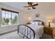 Bedroom with a large window, ceiling fan, soft carpet, and comfortable black metal bed frame at 286 Western Sky Cir, Longmont, CO 80501