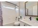 This modern bathroom features a shower over tub, white subway tile, and sleek vanity at 10117 Wyandott N Cir, Thornton, CO 80260