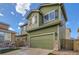 Exterior view of green home with two-car garage, stone accents, and manicured lawn at 10117 Wyandott N Cir, Thornton, CO 80260