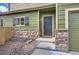 Home's front entrance features a covered entryway, stone accents, and low-maintenance gravel yard at 10117 Wyandott N Cir, Thornton, CO 80260