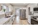 Bright kitchen featuring white cabinets, stainless steel appliances, and modern finishes at 10117 Wyandott N Cir, Thornton, CO 80260