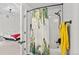 Bathroom features a tub with a shower and decorative shower curtain that peeks into the bedroom at 4100 Albion St # 314, Denver, CO 80216