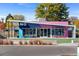 A modern, colorful exterior of DANG Soft Serve Ice Cream shop with outdoor seating at 4100 Albion St # 314, Denver, CO 80216