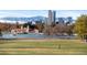 Picturesque park featuring a tranquil lake, boathouse, and Denver skyline backdrop at 4100 Albion St # 314, Denver, CO 80216