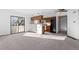 Open-concept living and kitchen area with carpet flooring and sliding glass door at 8701 Huron St # 5-210, Thornton, CO 80260