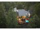 Aerial view of a beautiful home surrounded by lush greenery, featuring a deck with a hot tub at 2386 Daisy Ln, Golden, CO 80401
