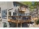 Back exterior view with a multi-level deck, hot tub, grill, and mature trees at 2386 Daisy Ln, Golden, CO 80401