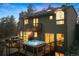 Back exterior view showcasing an expansive deck and an inviting hot tub, perfect for outdoor entertainment at 2386 Daisy Ln, Golden, CO 80401