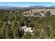 Scenic aerial view of a home surrounded by lush greenery, rolling hills, and distant snow-capped mountains at 2386 Daisy Ln, Golden, CO 80401