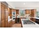 Elegant kitchen with wooden cabinets, stainless steel appliances, and a center island cooktop at 2386 Daisy Ln, Golden, CO 80401
