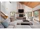 Bright living room with a vaulted wood ceiling, brick fireplace, and views of the surrounding landscape at 2386 Daisy Ln, Golden, CO 80401