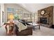 Bright living room with a stone fireplace, vaulted ceilings, and views of the surrounding landscape at 2386 Daisy Ln, Golden, CO 80401