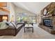 Bright living room with a stone fireplace, vaulted ceilings, and views of the surrounding landscape at 2386 Daisy Ln, Golden, CO 80401