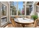 Bright sun room with a round table, wicker chairs, and large windows showcasing the surrounding trees at 2386 Daisy Ln, Golden, CO 80401