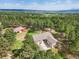 Breathtaking aerial view of a home surrounded by a lush forest and distant mountain views at 20125 Indi Dr, Monument, CO 80132