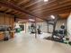 Unfinished basement with exposed wood ceiling, concrete floor, and fitness equipment at 20125 Indi Dr, Monument, CO 80132