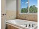 Bathroom featuring a soaking tub next to a bright window offering an outdoor view at 20125 Indi Dr, Monument, CO 80132