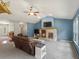 Bright living room features a brick fireplace, blue walls, and an open layout at 20125 Indi Dr, Monument, CO 80132