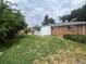 An overgrown backyard with trees, shrubbery, and wood fence provides a private outdoor space at 1088 Douglas Dr, Denver, CO 80221